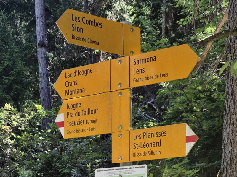 Descente à la Lienne. Un panneau qui montre les directions vers le bisse de Clavau, le bisse du Sillonin et le bisse de Lens. De nombreux bisses prennent leur source dans la vallée de la Lienne.