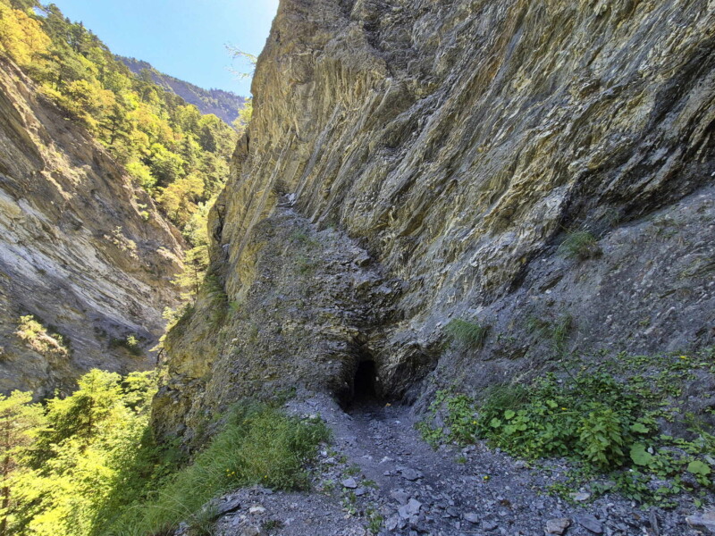 Gorges de la Lienne. L'arrivée a un tunnel creusé dans la roche par lequel passait le bisse de Clavau. Randonnée bisse de Clavau.