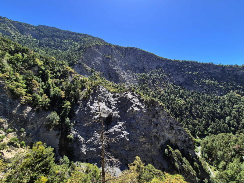 Gorges de la Lienne. La vue sur les falaises sur la rive opposée, à la gauche de la Lienne. On peut remarquer la trace horizontale au milieu de l'image du bisse du Sillonin. Randonnée bisse de Clavau.