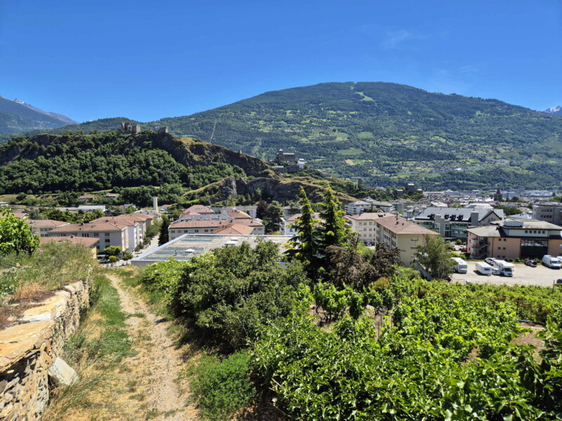 Le sentier descend pour rejoindre la ville de Sion. Vallée du Rhône - Sion. Randonnée bisse de Clavau.