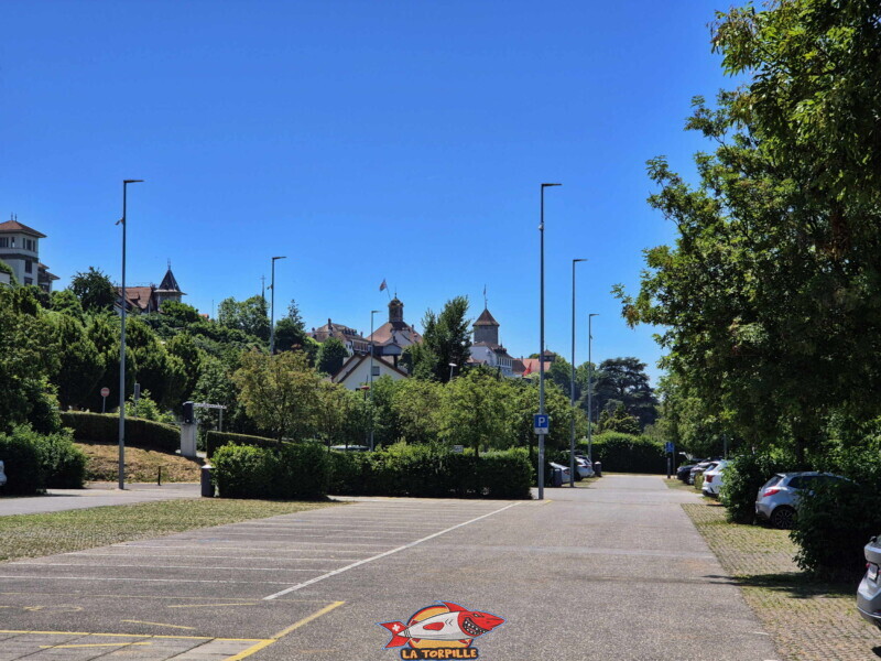 Le grand parking à côté de la Pantschau. En arrière-plan, le donjon du château de Morat. Le grand parking à côté de la Pantschau. En arrière-plan, le donjon du château de Morat.