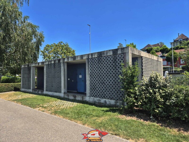 Des toilettes et des douches se trouvent entre le parking et la zone de pelouse de la Pantschau. Freizeitwiese Pantschau beim Hafen in Murten - Place de Loisirs Pantschau
