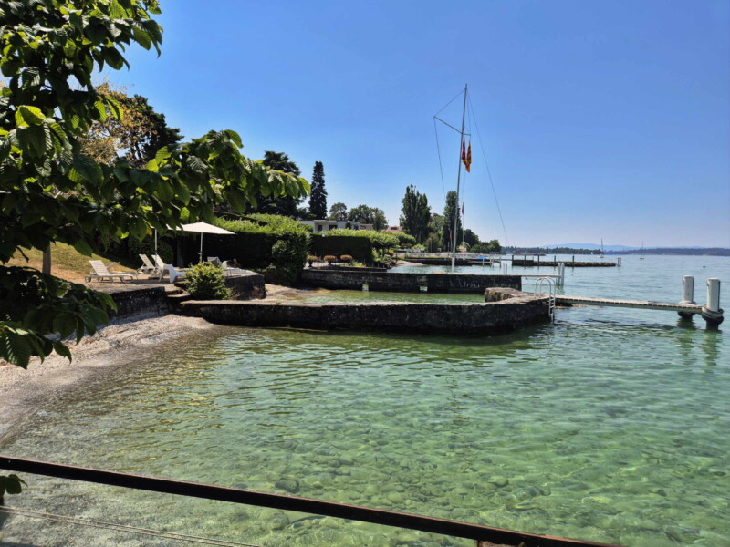 La vue sur le rivage en direction de Genève. Plage des Courbes. Anières, lac Léman, canton de Genève. La vue sur le rivage en direction de Genève. Plage des Courbes. Anières, lac Léman, canton de Genève.