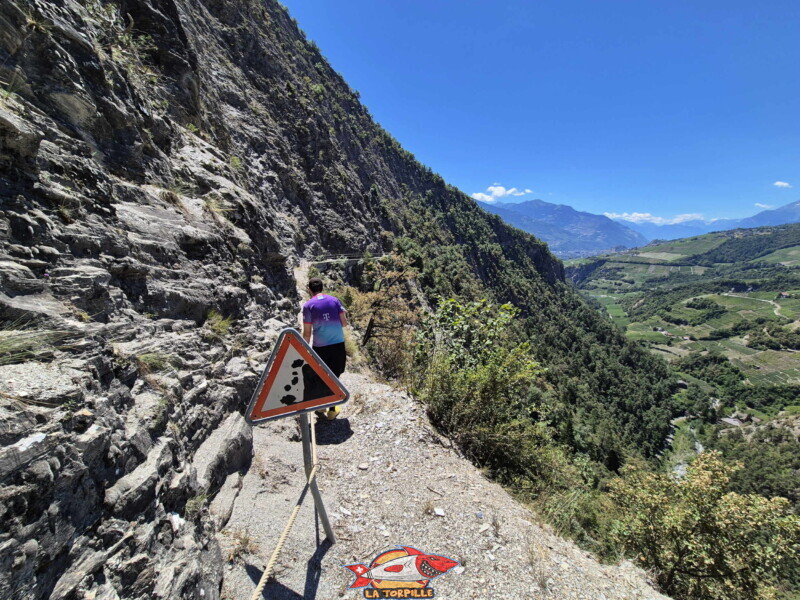 Après l'escalier, le sentier longe la paroi rocheuse à plat, mais un panneau indique des chutes de pierres. Après l'escalier, le sentier longe la paroi rocheuse à plat, mais un panneau indique des chutes de pierres. Bisse de Sillonin