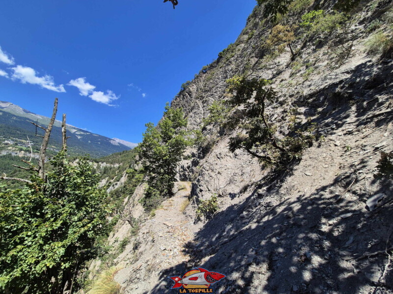 La vue vers l'arrière au milieu de paroi rocheuse. Bisse de Sillonin La vue vers l'arrière au milieu de paroi rocheuse. Bisse de Sillonin