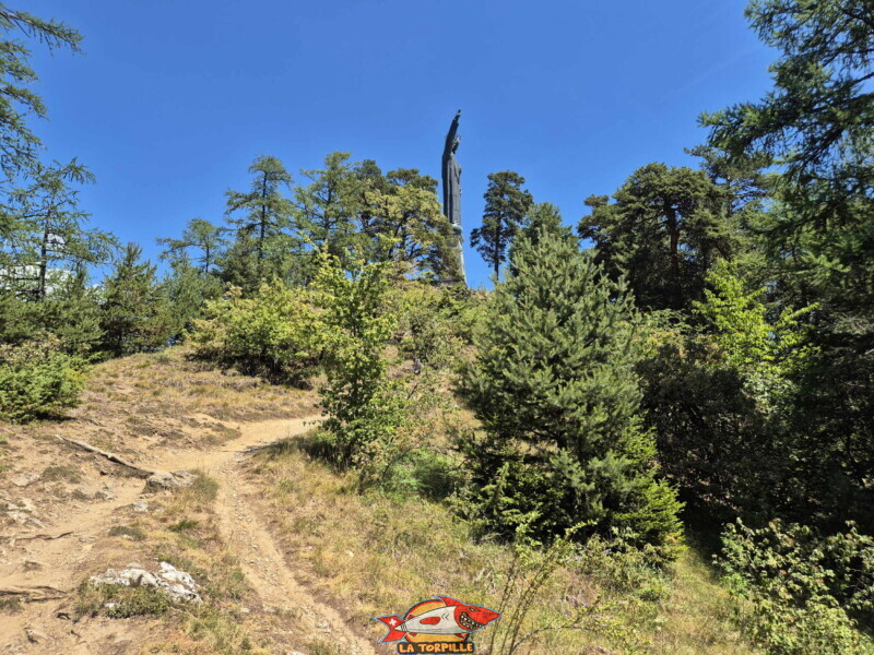 Descente dans la forêt. Statue du Christ-Roi, Lens, Valais central.