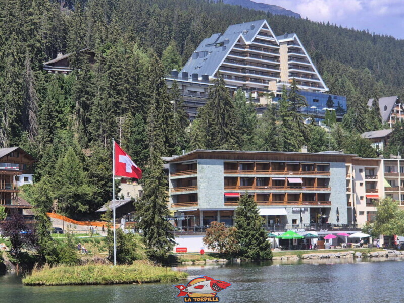 Le zoom sur l'hôtel Crans Ambassador. Le côté Sud de l'étang Grenon. Le zoom sur l'hôtel Crans Ambassador. Le côté Sud de l'étang Grenon.