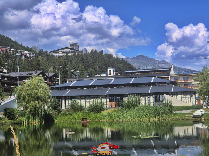 L'Orangerie avec, en arrière-plan, la tour de Super-Crans dans le quartier de Vermala de Crans-Montana. L'Orangerie avec, en arrière-plan, la tour de Super-Crans dans le quartier de Vermala de Crans-Montana. Côté Est, étang d'Ycoor. Crans-Montana