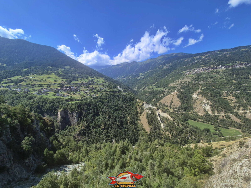 La vue depuis la passerelle vers l'aval. On aperçoit Euseigne sur la gauche et Hérémence sur la droite. Au milieu, les pyramides d'Euseigne. Le val d'Hérens, en bas, à l'horizontal. Au milieu, obliquement, le val d'Hérémence qui mène au barrage de la Grande-Dixence.