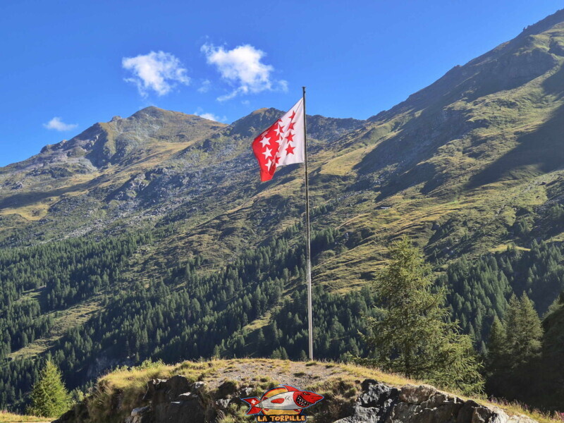 Le drapeau du canton du Valais flotte au niveau du Chargeur. Barrage de la Grande Dixence, Hérémence, canton du Valais. Le drapeau du canton du Valais flotte au niveau du Chargeur. Barrage de la Grande Dixence, Hérémence, canton du Valais.