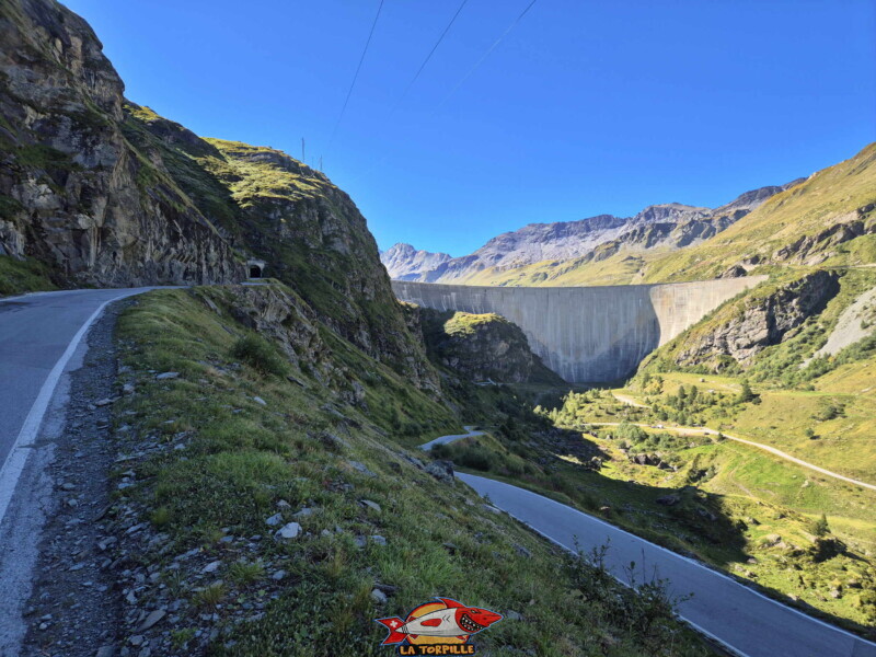 La route qui monte rive droite pour arriver au barrage avec le passage dans un tunnel. Barrage et lac de Moiry, tour du lac, val d'Anniviers, Valais. La route qui monte rive droite pour arriver au barrage avec le passage dans un tunnel. Barrage et lac de Moiry, tour du lac, val d'Anniviers, Valais.