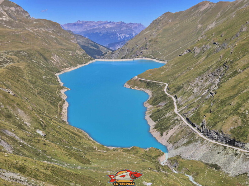 La vue sur le lac de Moiry avec, sur la gauche, le sentier du lac, et, sur la droite, la route. Barrage et lac de Moiry, tour du lac, val d'Anniviers, Valais. La vue sur le lac de Moiry avec, sur la gauche, le sentier du lac, et, sur la droite, la route. Barrage et lac de Moiry, tour du lac, val d'Anniviers, Valais.