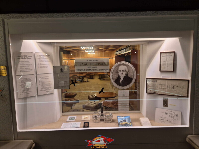 Située à la toute fin du parcours du musée de l'automobile (au deuxième sous-sol), cette vitrine rend hommage au valaisan Isaac de Rivaz (1752-1828), inventeur de génie, considéré comme le véritable pionnier du moteur à explosion.