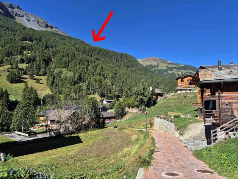 Le petit chemin qui sort d'Evolène pour rejoindre la route de Lanna. La flèche rouge indique la position du Gollié d'Arbey. Le petit chemin qui sort d'Evolène pour rejoindre la route de Lanna. La flèche rouge indique la position du Gollié d'Arbey. Gollié d'Arbey, val d'Hérens, Valais.